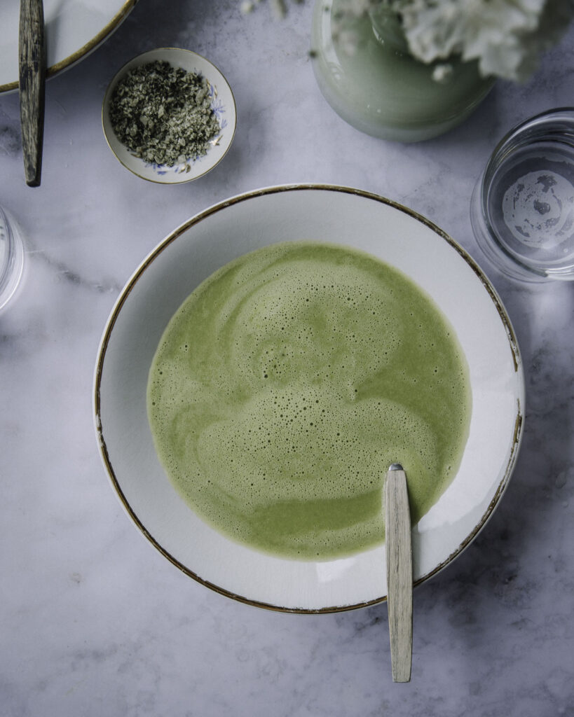 Hernesosekeitto on klassikkokeitto, joka valmistuu alle puolessa tunnissa. Kuvassa keitto on valkoisella lautasella, jossa on kultainen reunus. Keiton pinnalla on vaahtoa. Kuva ylälaidassa on toisen lautasen kulma, suolakippo sekä osa kukkamaljakkoa kukkineen. Kuva on otettu ylhäältäpäin.