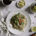 Pad Thai – se paras resepti! Täydelliset paistetut nuudelit onnistuvat helposti myös kotona. Kuvassa nuudelit on valkoisella lautasella.