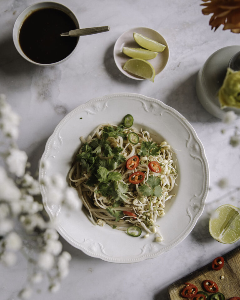 Pad Thai – se paras resepti! Täydelliset paistetut nuudelit onnistuvat helposti myös kotona. Kuvassa nuudelit on valkoisella lautasella.