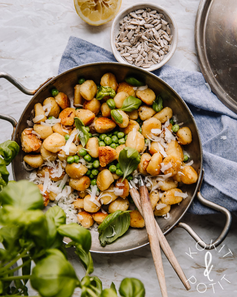 Gnocchi-reseptit ovat ihanan helppoja ja nopeita tehdä. Kuvassa on sitruunaiset gnocchit, joiden seassa on herneitä, yrttejä ja parmesaaniraastetta. Gnocchit ovat pyöreässä, kahvallisessa ja laakeassa metalliastiassa.