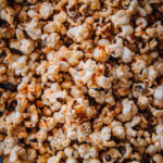 Gochujang-popcornit ovat sävyltään hennon oranssisia. Koko kuva on täynnä popcorneja.