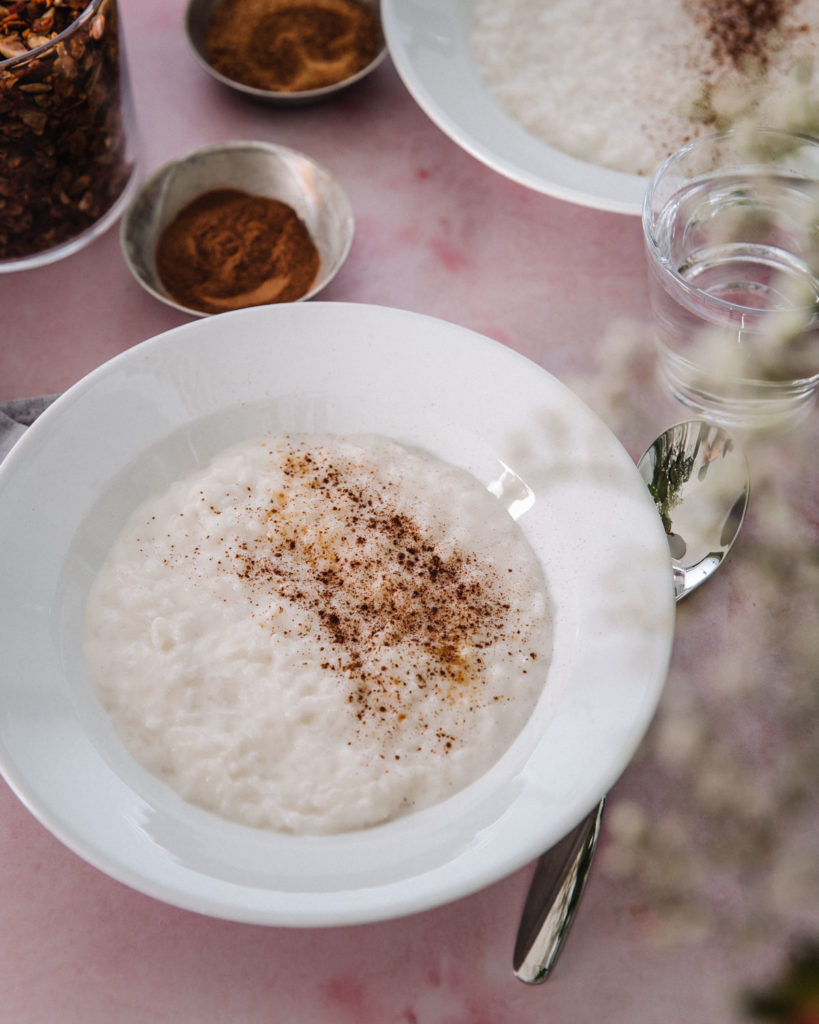 Kookoksinen riisipuuro on täyteläinen ja maidoton vaihtoehto perinteiselle riisipuurolle. 

Puuro on valkoisella lautasella. Puuron päällä on kanelia ja ruskeaa kookossokeria. Kuvan alusta on vaalenpunainen. Kuvassa on osin myös toinen puurolautanen sekä pienet kaneli- ja sokerikupit.