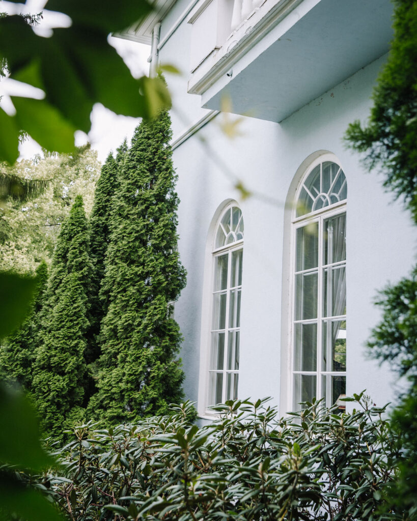 Haikon historia ulottuu 1300-luvulle. Kuvassa kartanon kauniit kaari-ikkunat sekä vihreää kasvillisuutta.