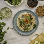 Shanghai-tacot yhdistää aasialaiset maut tacojen helppouteen. Keskellä on sinertävällä lautasella partha-letun päälle koottu Shanghai-taco ja ympärillä on kipoissa tacon aineksia. Kuva on otettu ylhäältäpäin.